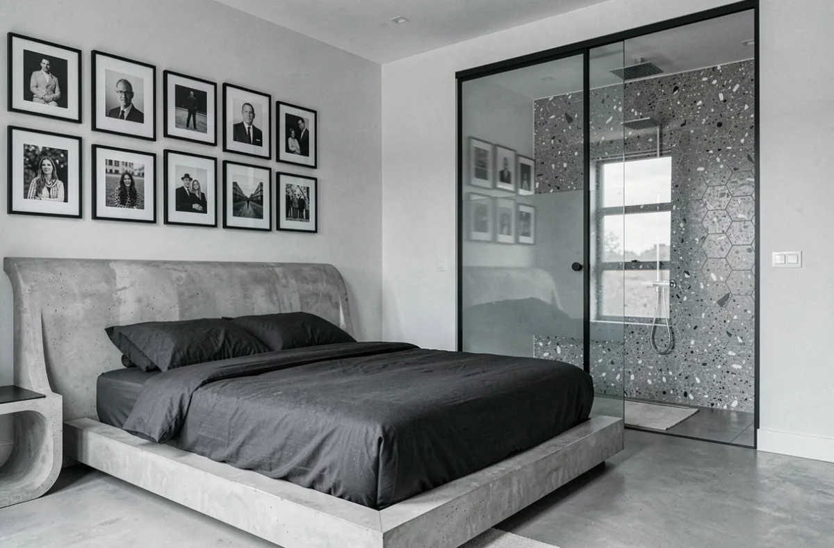 Chambre design de 1.75 Paris La Trêve avec tête de lit en béton sculpté, literie monochrome et galerie de photographies noir et blanc
