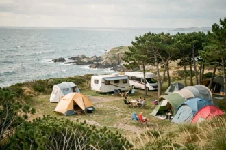 Vue panoramique d'un camping en bord de mer dans le Finistère avec tentes colorées et vue sur la côte bretonne