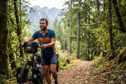 Homme en vélo de randonnée dans la forêt verte
