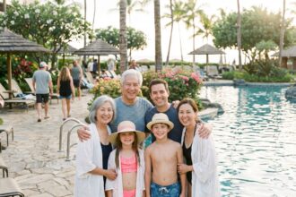 Famille multigenerational souriante au bord de la piscine