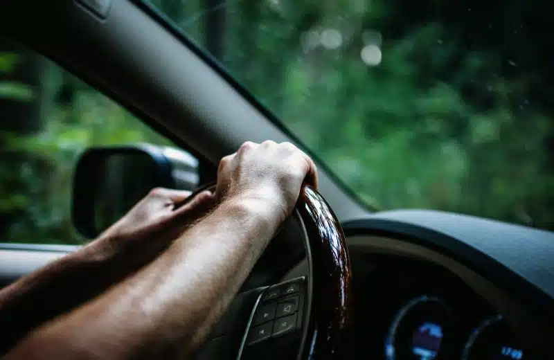 des mains sur le volant d'une voiture