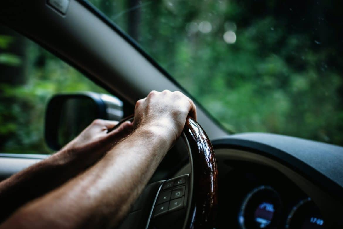 des mains sur le volant d'une voiture